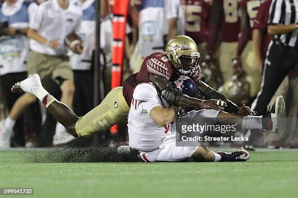 Matthew Thomas of the Florida State Seminoles tackles Chad Kelly of the Mississippi Rebels in the first half during the Camping World Kickoff at...