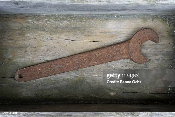 directly above shot of rusty wrench on wood - schraubenschlüssel stock-fotos und bilder