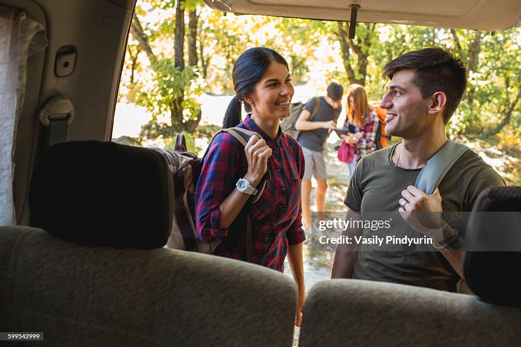 Happy man and woman looking at each other seen from car