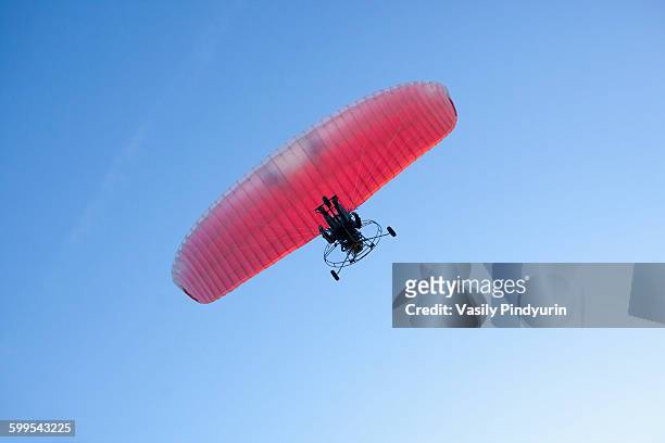 low angle view of person motor paragliding against clear blue sky - motor paraglider stock pictures, royalty-free photos & images