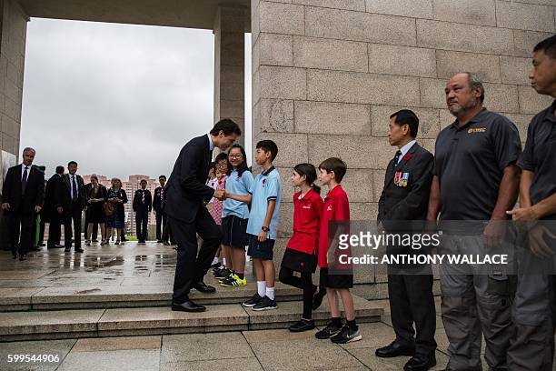 Canadian Prime Minister Justin Trudeau meets young well wishers after laying a wreath at the Sai Wan War Cemetery during his visit to Hong Kong on...