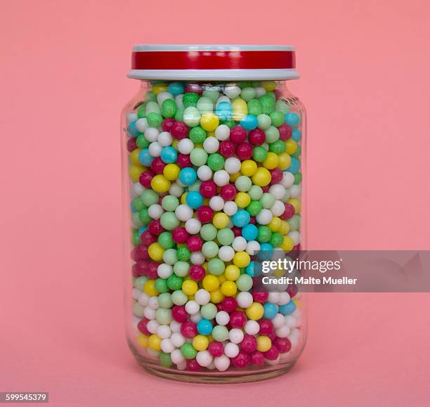 jar full of candies against pink background - sweet jar stock pictures, royalty-free photos & images