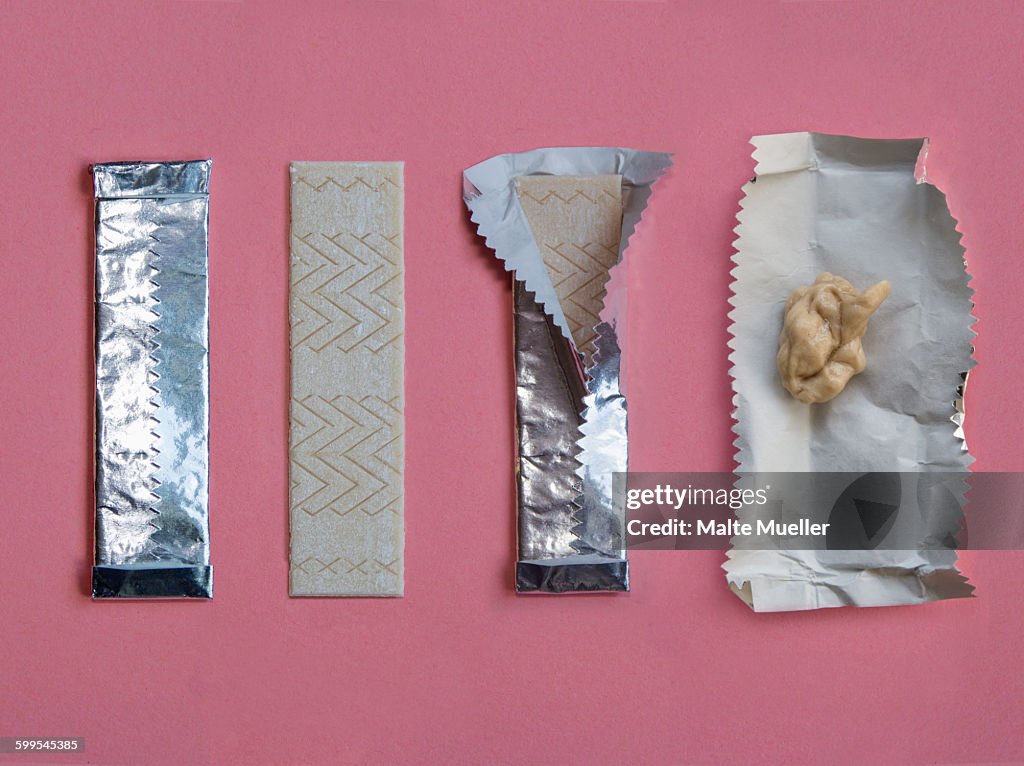 Progressive stages of bubble gum being chewed against pink background