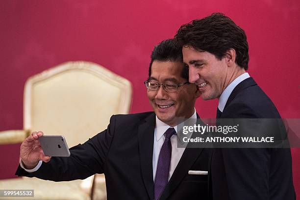 Canadian Prime Minister Justin Trudeau poses for a selfie with Secretary for Commerce and Economic Development of Hong Kong Greg So, during a...