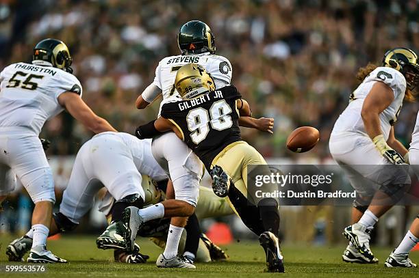 Linebacker Jimmie Gilbert of the Colorado Buffaloes hits quarterback Nick Stevens of the Colorado State Rams and forces a fumble at Sports Authority...