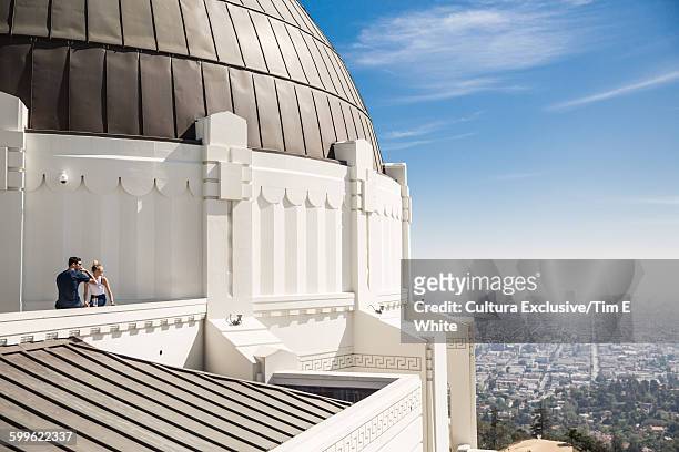 couple look over la from griffith park observatory, los angeles, california, usa - cultura americana stock pictures, royalty-free photos & images