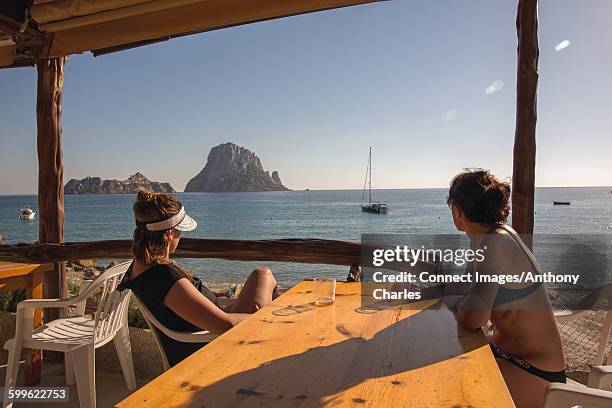 two female tourists looking over to es vedra, ibiza, spain - es vedra stock pictures, royalty-free photos & images