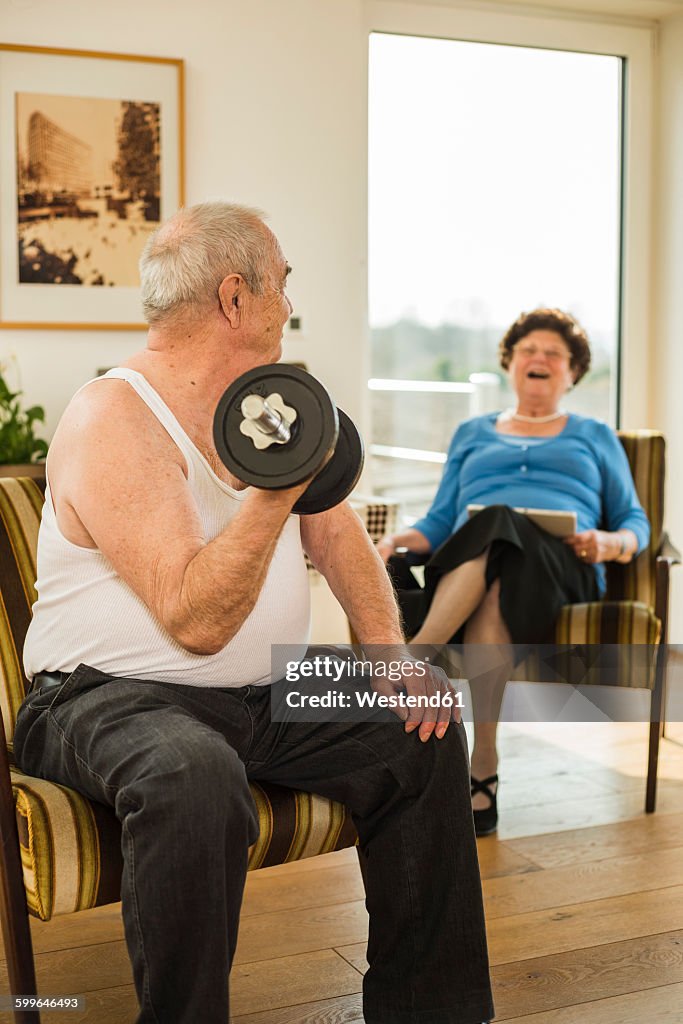 Senior man with dumbbell at home