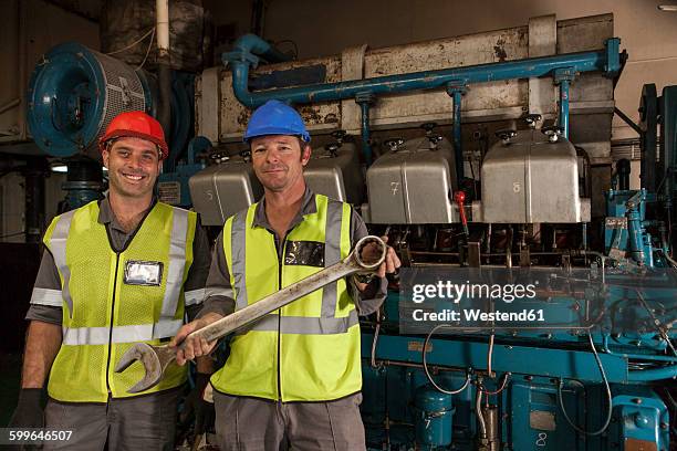 portrait of two smiling mechanics in engine room on a ship - エンジンルーム ストックフォトと画像
