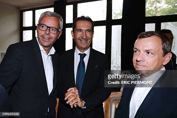 Telecom Company Altice N.V group CEO and CEO of SFR Michel Combes talks with Altice founder Patrick Drahi and the President of the NextRadioTV group...