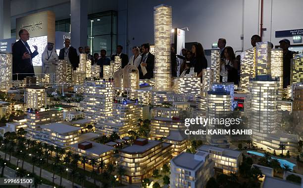 Visitors gather near a model of the centre of the Jumeriah district at the annual Cityscape show on September 6 in the Gulf emirate of...