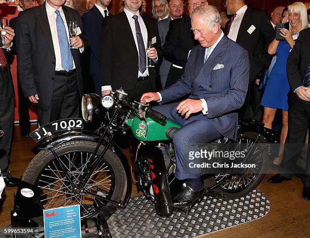 Prince Charles, Prince of Wales tries a 1933 BSA 500cc motorbike used for delivering telegrams as he attends a reception to mark the 500th...