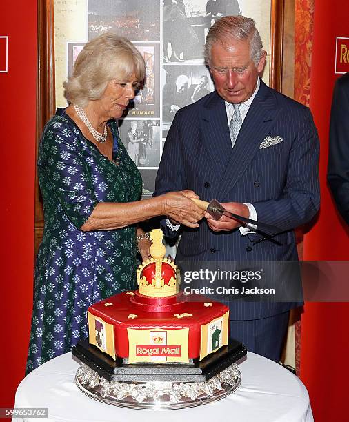 Prince Charles, Prince of Wales and Camilla, Duchess of Cornwall cut into a celebratory Royal Mail 500 Cake as they attend a reception to mark the...