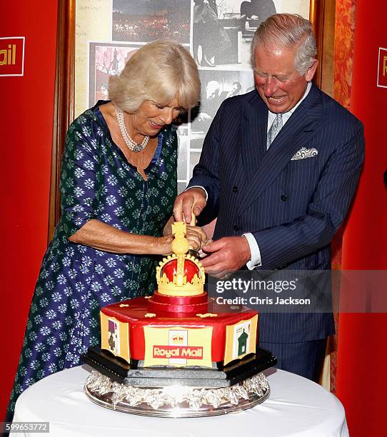 Prince Charles, Prince of Wales and Camilla, Duchess of Cornwall cut into a celebratory Royal Mail 500 Cake as they attend a reception to mark the...