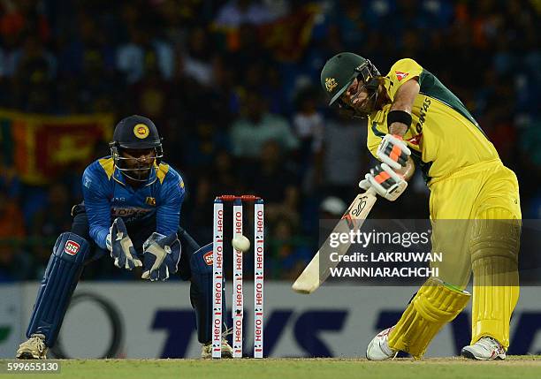 Australia's Glenn Maxwell is watched by Sri Lanka's wicketkeeper Kusal Perera as he hits a ball to the boundary during the first T20 international...