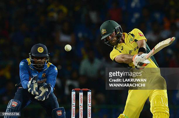 Australia's Glenn Maxwell is watched by Sri Lanka's wicketkeeper Kusal Perera as he hits a ball to the boundary during the first T20 international...