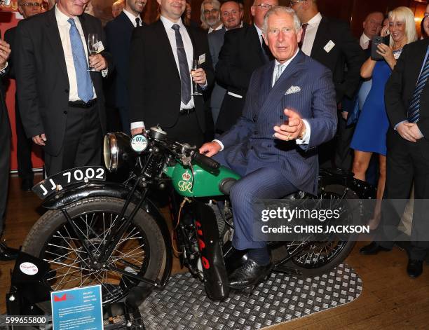 Britain's Prince Charles, Prince of Wales reacts as he sits on a 1933 BSA 500cc motorbike, used for delivering telegrams, during a reception to mark...