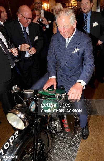 Britain's Prince Charles, Prince of Wales reacts as he sits on a 1933 BSA 500cc motorbike, used for delivering telegrams, during a reception to mark...