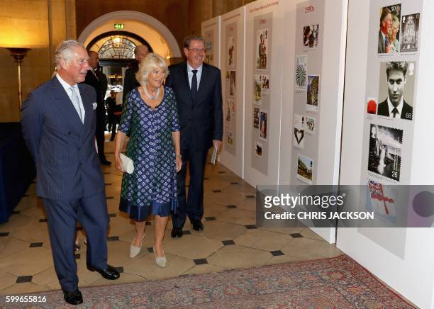 Britain's Prince Charles, Prince of Wales and his wife Britain's Camilla, Duchess of Cornwall , view a selection of postage stamps during a reception...