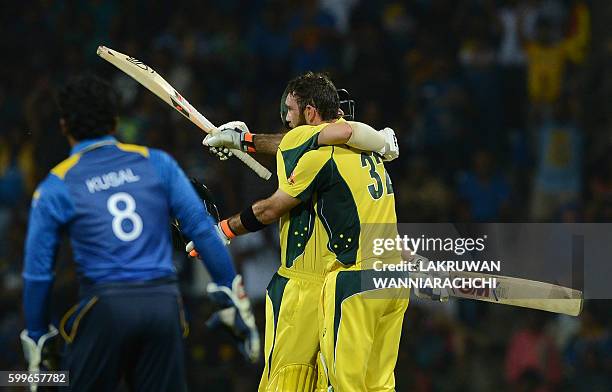 Australia's Glenn Maxwell is congratulated by his teammate Travis Head after scoring a century during the first T20 international cricket match...