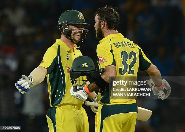 Australia's Glenn Maxwell is congratulated by his teammate Travis Head after scoring a century during the first T20 international cricket match...
