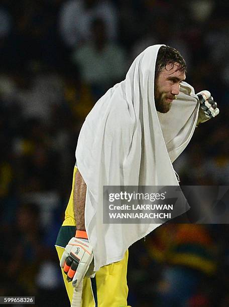 Australia's Glenn Maxwell takes a quick break under a towel during the first T20 international cricket match between Sri Lanka and Australia at the...