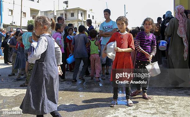 Syrians wait with their buckets as The Foundation for Human Rights and Freedoms And Humanitarian Relief gives hot meal at Martyrs Square as the...