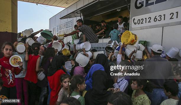 Syrians wait with their buckets as The Foundation for Human Rights and Freedoms And Humanitarian Relief gives hot meal at Martyrs Square as the...