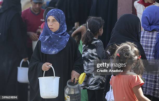 Syrians wait with their buckets as The Foundation for Human Rights and Freedoms And Humanitarian Relief gives hot meal at Martyrs Square as the...