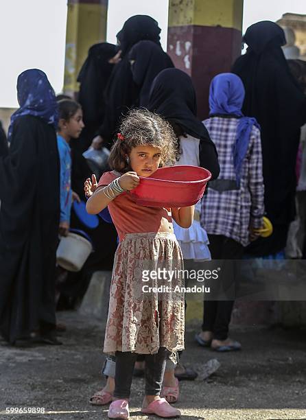 Syrians wait with their buckets as The Foundation for Human Rights and Freedoms And Humanitarian Relief gives hot meal at Martyrs Square as the...