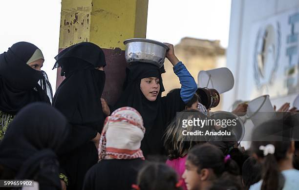 Syrians wait with their buckets as The Foundation for Human Rights and Freedoms And Humanitarian Relief gives hot meal at Martyrs Square as the...