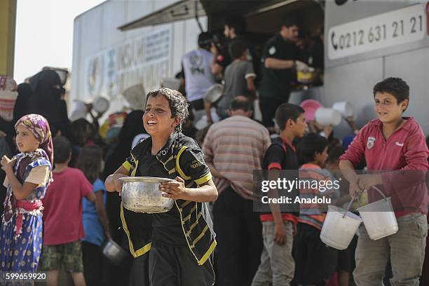 Syrians wait with their buckets as The Foundation for Human Rights and Freedoms And Humanitarian Relief gives hot meal at Martyrs Square as the...