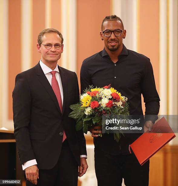 Bayern Munich football star Jerome Boateng poses with the 2016 Moses Mendelssohn Award after receiving it from Berlin Mayor Michael Mueller on...