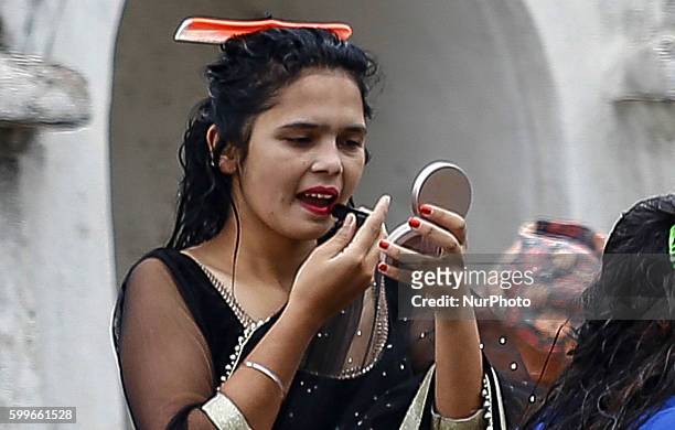 Nepalese Hindu women does her make up after performing ritual bath in the Bagmati River during the Rishi Panchami festival in Kathmandu, Nepal,...