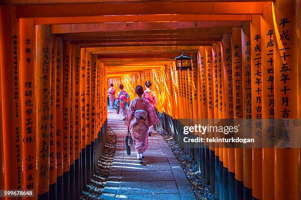 young japanese girls  walking at fushimi-inari temple in kyoto japan - inari shrine stock pictures, royalty-free photos & images