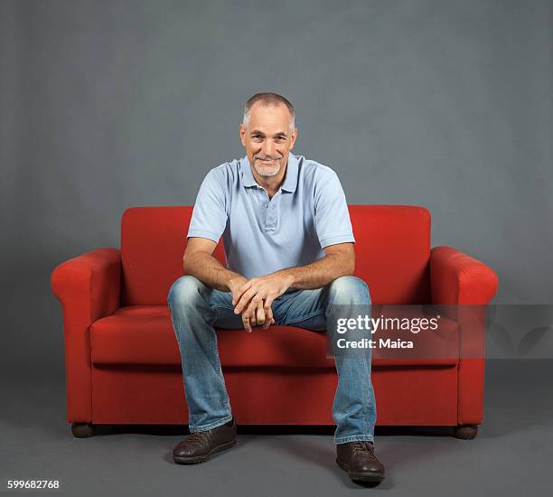 retrato de hombre maduro alegre - man sitting on sofa fotografías e imágenes de stock