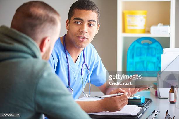gp and patient chat - male doctor man patient stock pictures, royalty-free photos & images