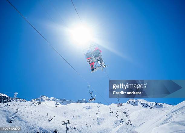 couple in a ski lift chair - couple ski lift stockfoto's en -beelden
