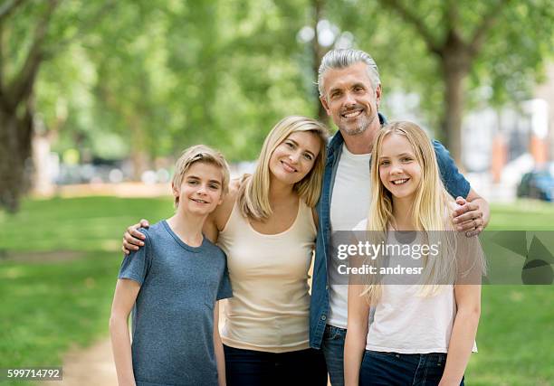 happy family portrait at the park - four people smiling stock pictures, royalty-free photos & images