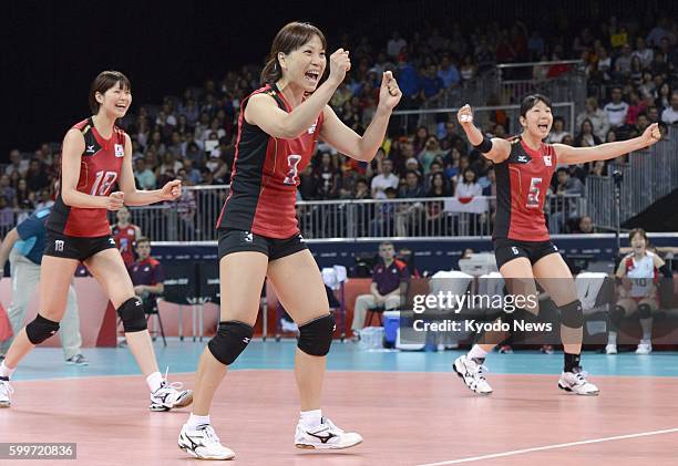 Britain - Saori Kimura, Yoshie Takeshita, and Erika Araki rejoice after the team scored during the third set of a match against Algeria in the...