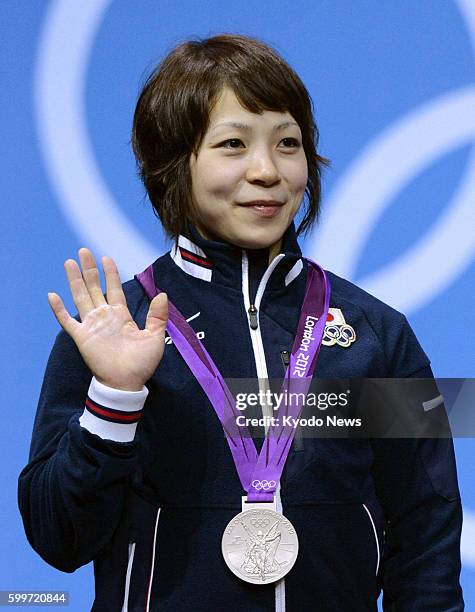 Britain - Hiromi Miyake waves after winning a silver medal in the Olympic women's weightlifting 48-kilogram class at ExCel London on July 28, 2012.