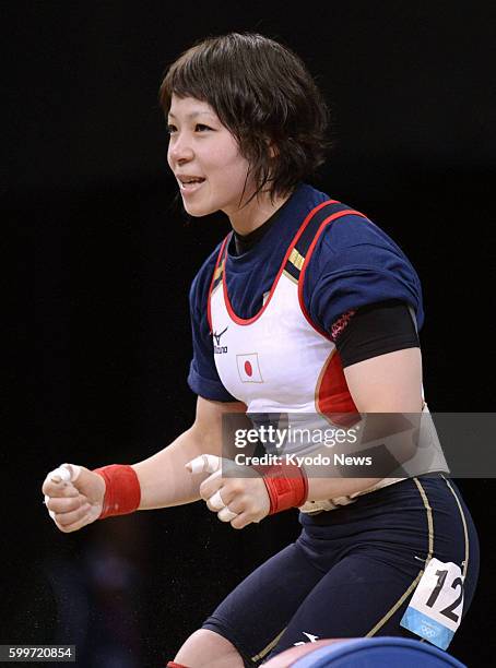 Britain - Hiromi Miyake celebrates after successfully lifting 110 kilograms in the clean and jerk during the Olympic women's weightlifting 48-kg...