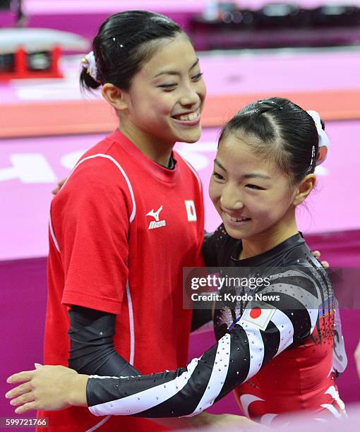 Britain - Yuko Shintake and Asuka Teramoto embrace after their performance in the London Olympics women's gymnastics qualification round at North...