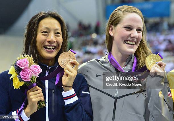 Britain - Aya Terakawa of Japan holds up her bronze medal with gold medalist Missy Franklin of the United States during the award ceremony for the...