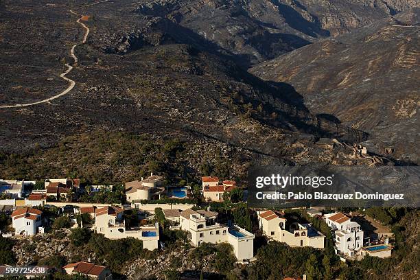 Burned fields surround houses after a wildfire on the coastline on September 6, 2016 in Benitachell, near Javea, in Valencia province, Spain....