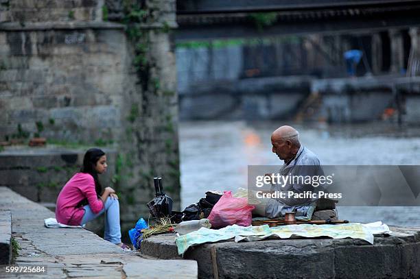 Priest offering ritual prayer at the Bank of Bagmati River of Pashupatinath Temple during Rishi Panchami Festival celebrations at Pashupatinath...