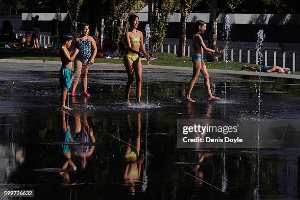 Children cool down in a fountain in the Madrid Rio playground on September 6, 2016 in Madrid, Spain. A three-day heatwave has hit central and...