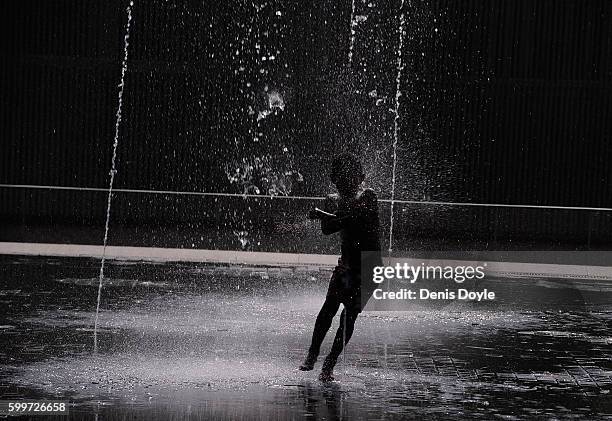 Young boy runs while cooling down in a fountain in the Madrid Rio playground on September 5, 2016 in Madrid, Spain. A three-day heatwave has hit...