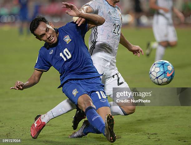 Teerasil Dangda of Thailand is tackled by Japan player during the 2018 World Cup Qualifiers match between Thailand and Japan at Rajamangala Stadium...