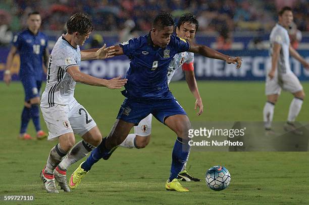 Siroch Chatthong of Thailand is closed down by Japan players during the 2018 World Cup Qualifiers match between Thailand and Japan at Rajamangala...